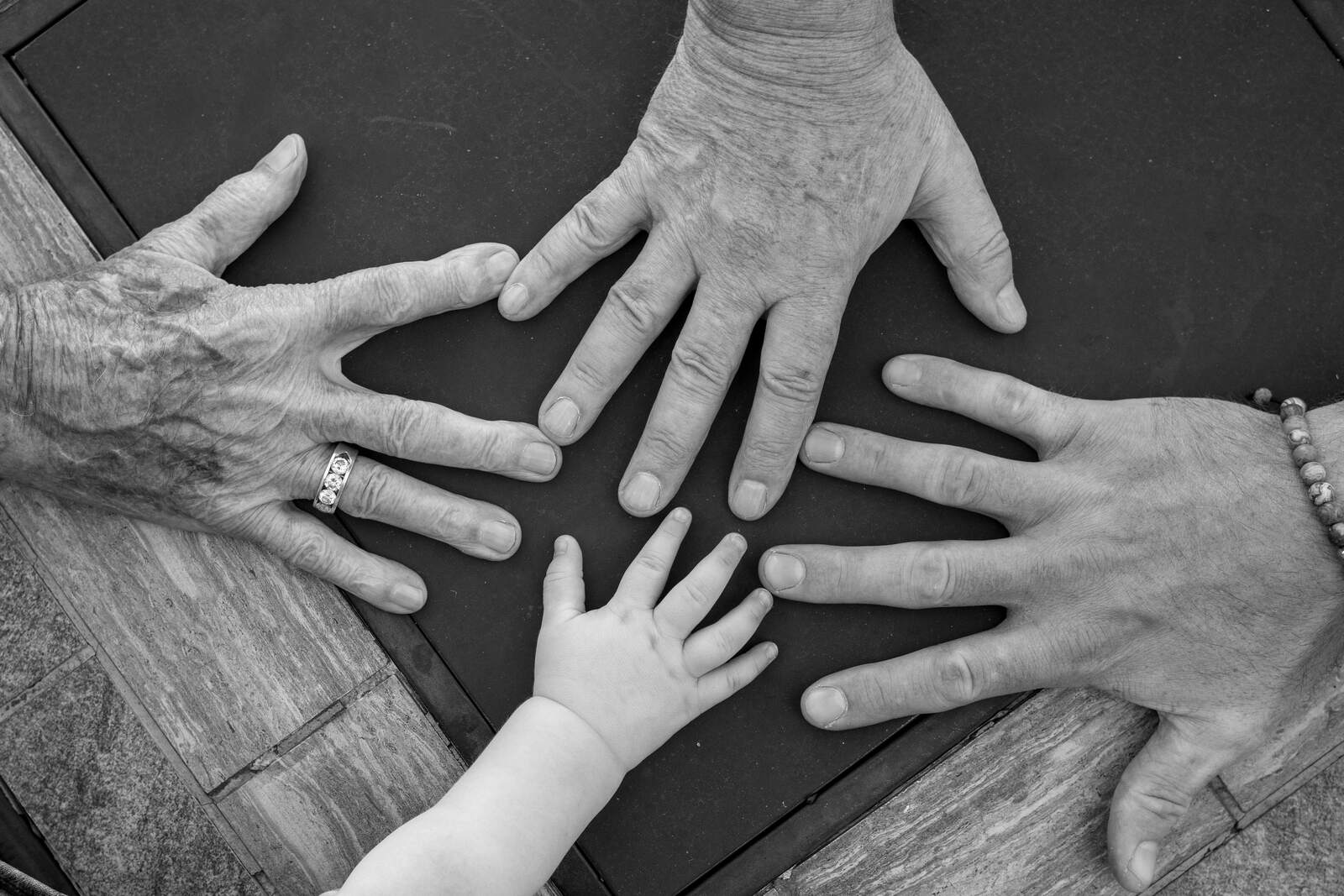 Hands of three generations resting together
